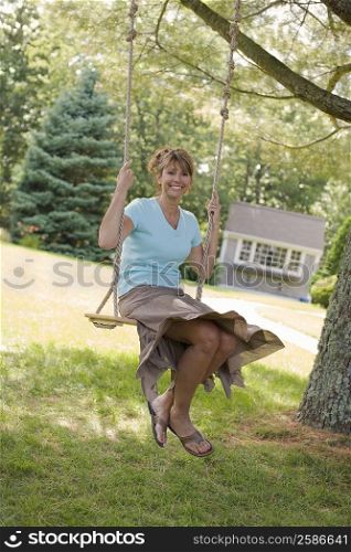 Portrait of a mature woman swinging on a rope swing