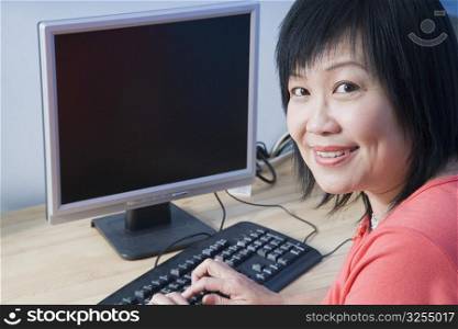 Portrait of a mature woman using a computer and smiling