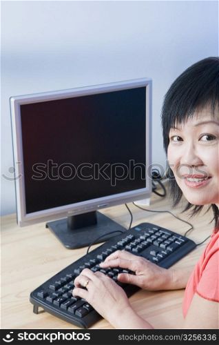 Portrait of a mature woman using a computer and smiling