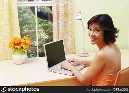 Portrait of a mature woman using a laptop and smiling
