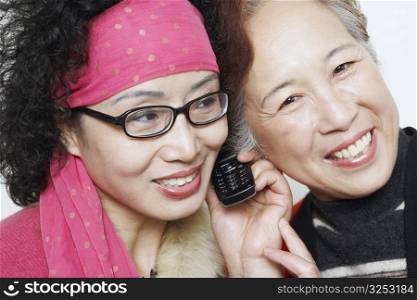 Portrait of a mature woman with her friends using a mobile phone