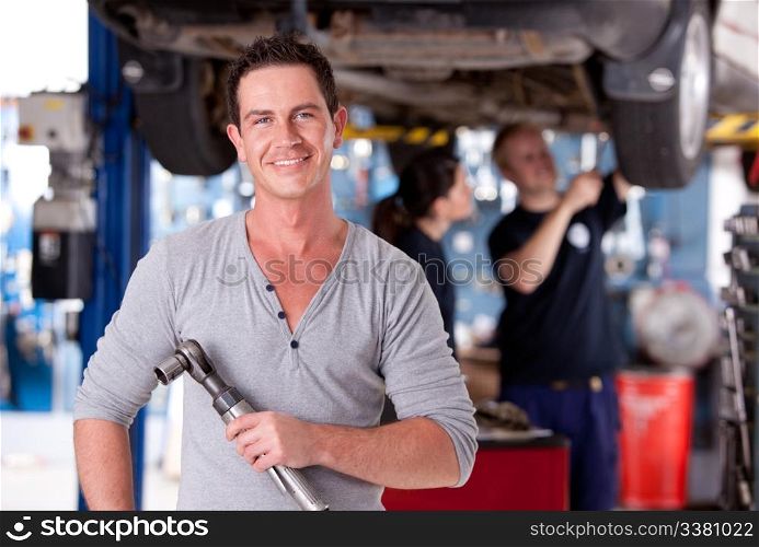 Portrait of a mechanic holding an air powered socket