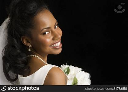 Portrait of a mid-adult African-American bride on black background.