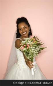 Portrait of a mid-adult African-American bride on pink background.