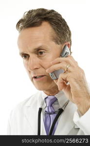 Portrait of a mid-adult Caucasian male doctor with stethoscope around his neck talking on cell phone.