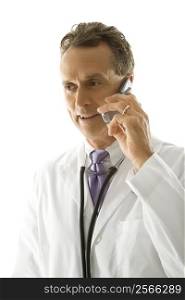 Portrait of a mid-adult Caucasian male doctor with stethoscope around his neck talking on cell phone.