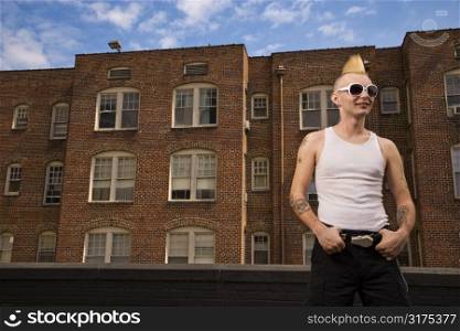Portrait of a mid-adult Caucasian male punk outside with building in background.