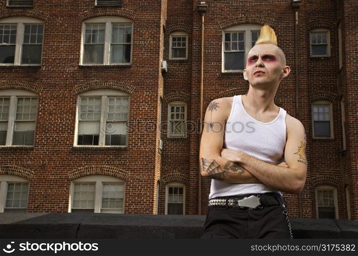 Portrait of a mid-adult Caucasian male punk with building in background.