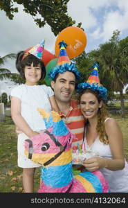 Portrait of a mid adult couple celebrating birthday with their daughter