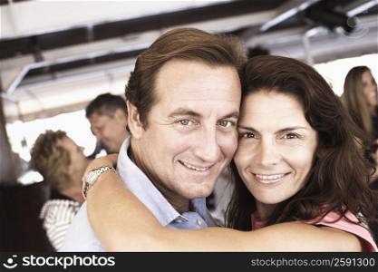 Portrait of a mid adult couple embracing each other in a nightclub