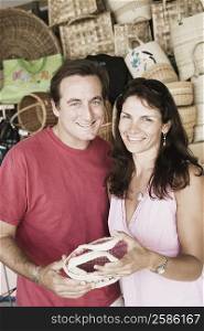 Portrait of a mid adult couple holding a hand bag and smiling