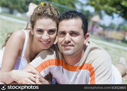 Portrait of a mid adult couple lying in a lawn