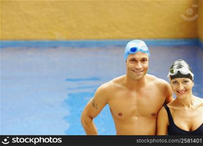 Portrait of a mid adult couple standing near a swimming pool and smiling