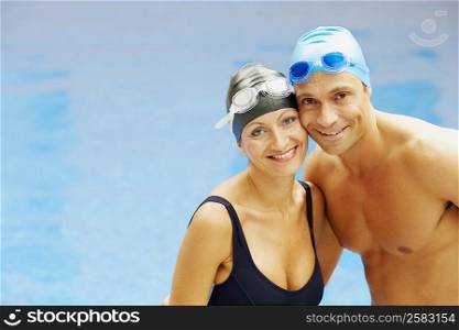 Portrait of a mid adult couple standing near a swimming pool and smiling