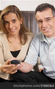 Portrait of a mid adult couple using a remote control