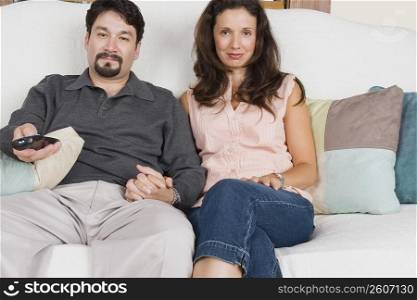 Portrait of a mid adult couple watching television