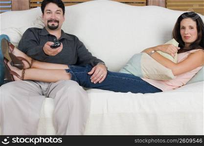 Portrait of a mid adult couple watching television