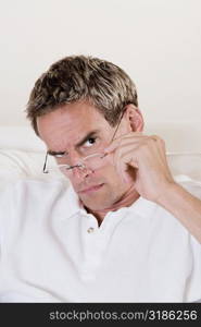 Portrait of a mid adult man adjusting his eyeglasses