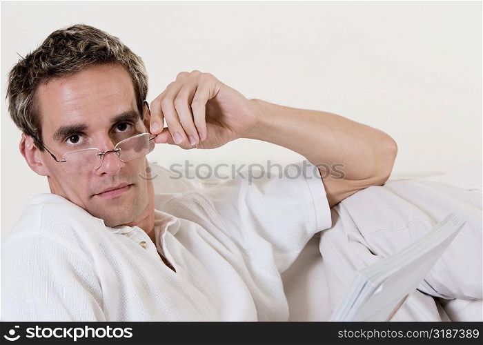 Portrait of a mid adult man adjusting his eyeglasses