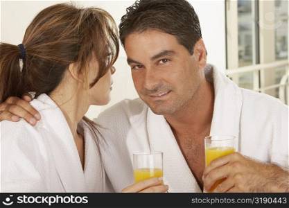 Portrait of a mid adult man and a mid adult woman holding a glass of juice