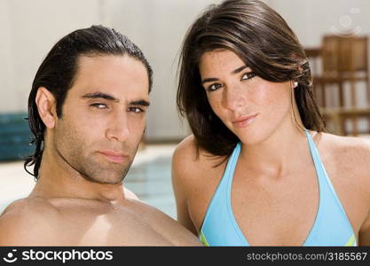 Portrait of a mid adult man and a young woman at the poolside