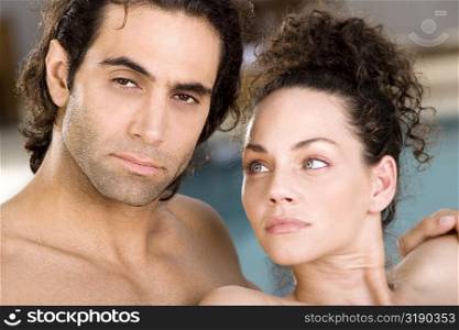 Portrait of a mid adult man and a young woman at the poolside