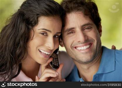 Portrait of a mid adult man and a young woman holding a mobile phone