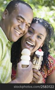 Portrait of a mid adult man and a young woman holding ice creams