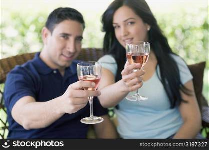 Portrait of a mid adult man and a young woman holding wine glasses