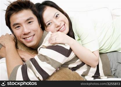 Portrait of a mid adult man and a young woman lying on a couch