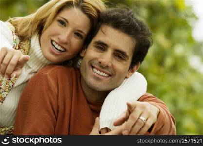 Portrait of a mid adult man and a young woman pointing forward