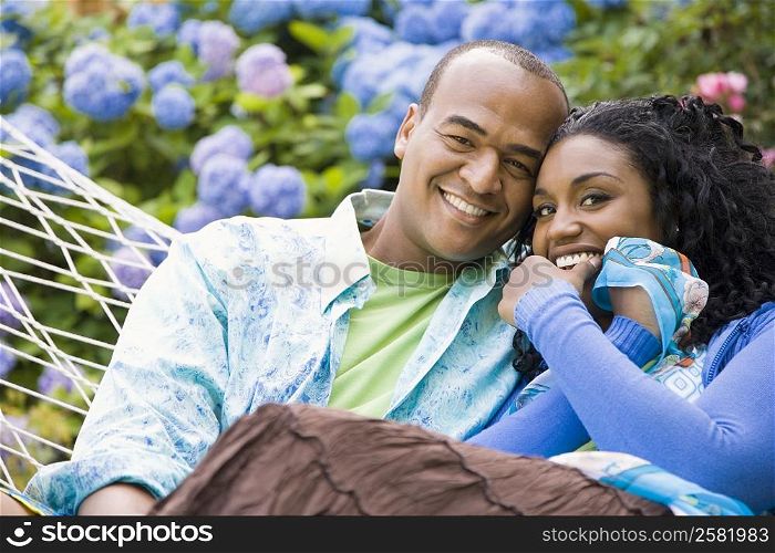 Portrait of a mid adult man and a young woman resting in a hammock