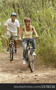 Portrait of a mid adult man and a young woman riding bicycles