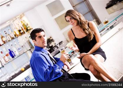 Portrait of a mid adult man and a young woman sitting in a bar