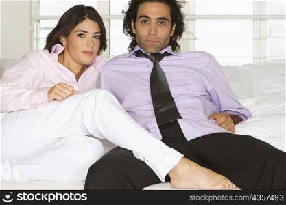 Portrait of a mid adult man and a young woman sitting on a couch