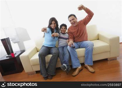 Portrait of a mid adult man and a young woman sitting with their son on a couch and smiling