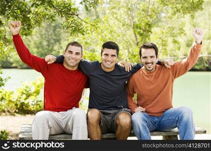 Portrait of a mid adult man and two young men sitting on a bench