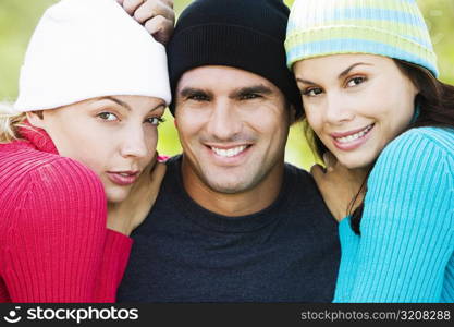 Portrait of a mid adult man and two young women smiling