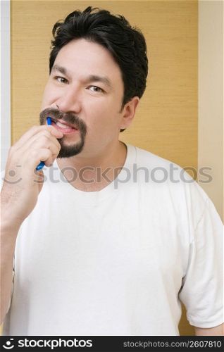 Portrait of a mid adult man brushing his teeth