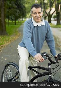 Portrait of a mid adult man cycling in a park