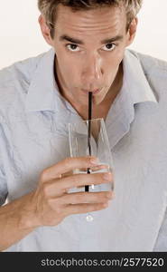 Portrait of a mid adult man drinking water with a straw