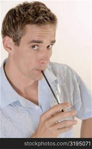 Portrait of a mid adult man drinking water with a straw