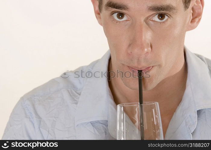 Portrait of a mid adult man drinking with a straw