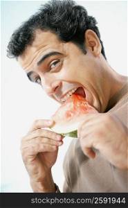 Portrait of a mid adult man eating a slice of watermelon