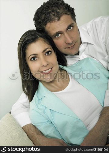 Portrait of a mid adult man embracing a mid adult woman form behind