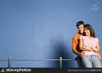 Portrait of a mid adult man embracing a mid adult woman from behind