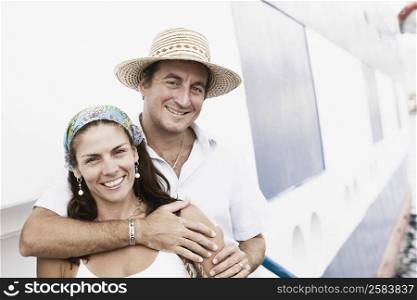 Portrait of a mid adult man embracing a mid adult woman from behind and smiling