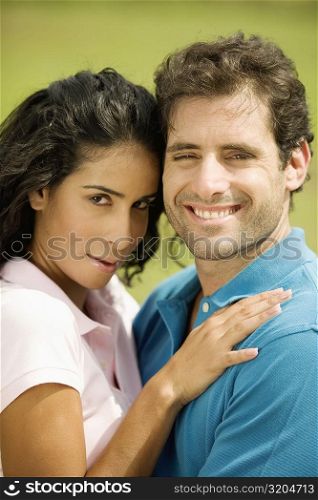 Portrait of a mid adult man embracing a young woman