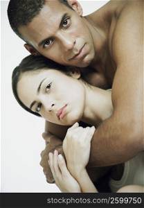 Portrait of a mid adult man embracing a young woman from behind