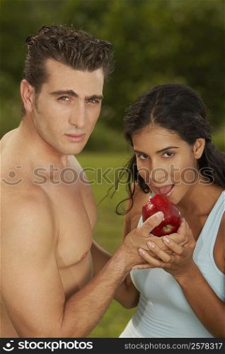 Portrait of a mid adult man feeding a young woman an apple